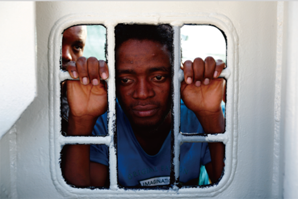 NGO「国境なき医師団（MSF）」の救助船“ブルボン・アルゴ号”から窓の外を見つめる移民。